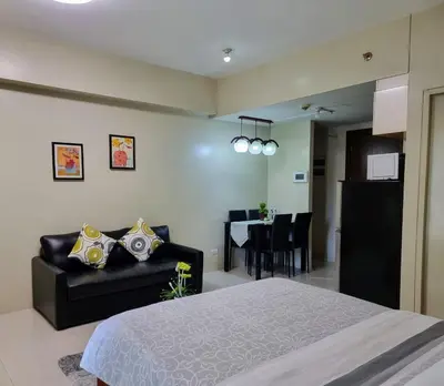 a bedroom with a bed and a couch and a table at One Palm Tree Villas Condo Across NAIA Terminal 3 in Manila