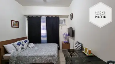 a small bedroom with a bed and a table at Mack's Awesome 15 with Netflix and FastUnliwifi in Manila