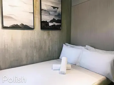 a bedroom with a white bed with two pictures on the wall at Sea Residences MOA arena SMX by darpm in Manila