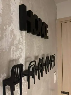 a sign on a wall with chairs and a sign that reads home at Sea Residences MOA arena SMX by darpm in Manila