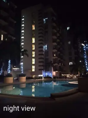 a night view of a swimming pool in a city at One Palm Tree Villas NAIA TERMINAL 3 in Manila
