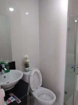 a white bathroom with a toilet and a sink at One Palm Tree Villas NAIA TERMINAL 3 in Manila