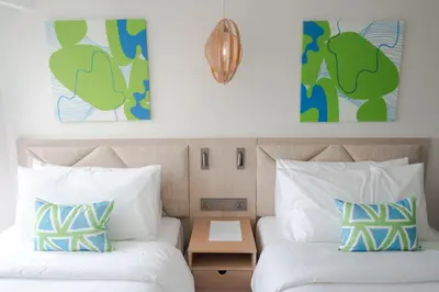 two beds in a hotel room with two pillows at Lime Resort Manila in Manila