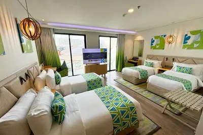 a hotel room with three beds and a couch at Lime Resort Manila in Manila