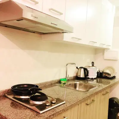 a kitchen counter with a sink and a stove at The Sentinel Residences in Manila