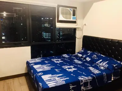 a bedroom with a bed and a window at The Sentinel Residences in Manila