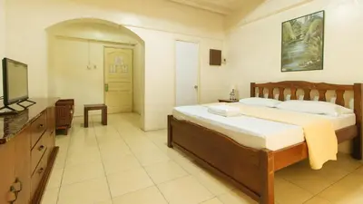 a bedroom with a bed and a flat screen tv at Casa Micarosa Hotel and Residences by RedDoorz in Manila
