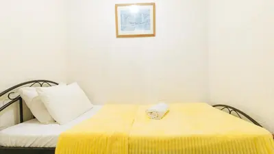 a small room with a bed with a yellow blanket at JBs Transient House in General Trias