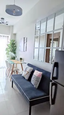 a living room with a blue couch and a table at SMDC Coast Residences near PICC World Trade Center MOA in Manila