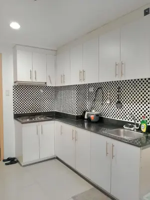 a kitchen with white cabinets and a sink at Sea Residences TowerE-F by EZStays in Manila