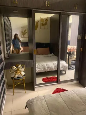 a woman taking a picture of a bedroom with a mirror at BayBreeze Haven Nest in Manila