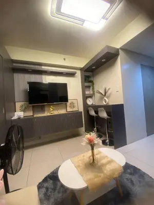 a living room with a table and a tv at BayBreeze Haven Nest in Manila
