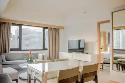 a living room with a table and a living room with a couch at Seda Bonifacio Global City Manila in Manila