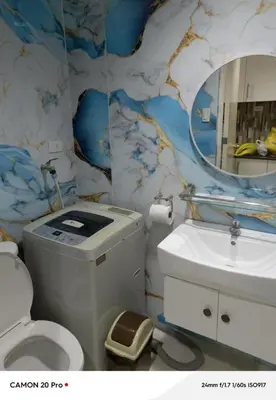 a bathroom with a toilet and a sink and a mirror at MOA Rental in Manila