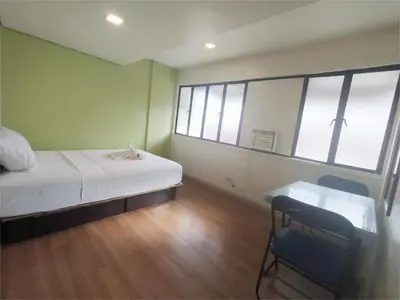 a bedroom with a bed and a desk and windows at Sulit Condo Unit Santa Mesa Manila in Manila