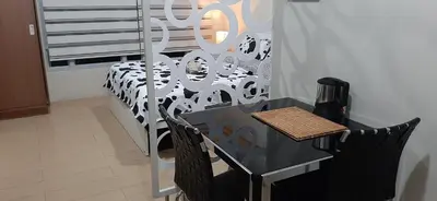a table and chairs in a room with a bed at Cozy City View Condo @ Newport NAIA T3 Airport & RWM in Manila