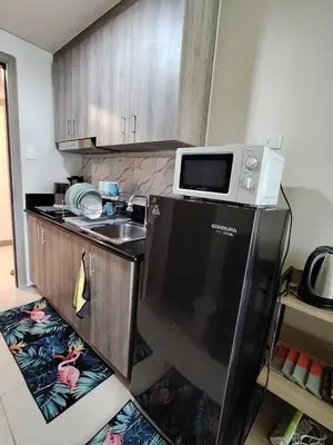 a kitchen with a microwave on top of a refrigerator at SMDC Coast Residences - Entire 1BR Condo with stunning view from 24th Floor in Manila