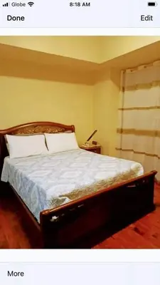 a bedroom with a bed with a wooden head board at 16E 1 BR Mosaic staycation in Manila