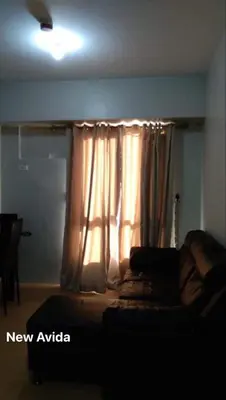 a bedroom with a bed and a window with a curtain at New Avida JVB Homestyle in Manila