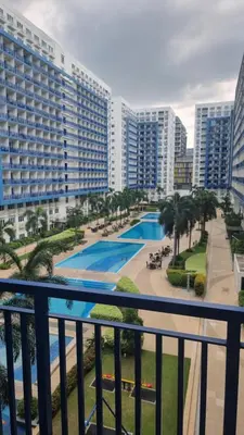 a balcony with a view of a pool and buildings at EZPlace Sea Residences in Manila