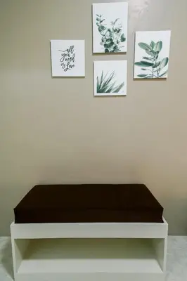 a bench in a room with pictures on the wall at TARASA HOSTEL in Manila