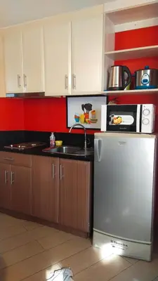a kitchen with a refrigerator and a microwave at Affordable Suite at 150 Newport Blvd near NAIA T3 in Manila