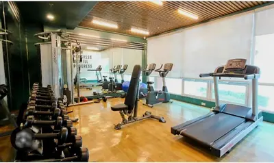 a gym with several treadmills and cardio machines at The Lancris Residences, 2 Bedrooms, 1 Bathroom, Living-room, Kitchen & Pool is Free in Manila
