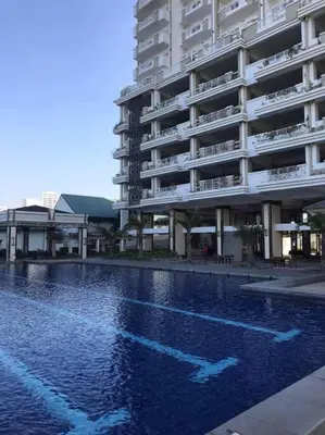a swimming pool in front of a large building at Torre DeManila TaftAvenue KingBed1bedroomBalcony 65InchesTV Rooftop Viewing LunetaPark ManilaOcean ManilaBay US Embassy in Manila