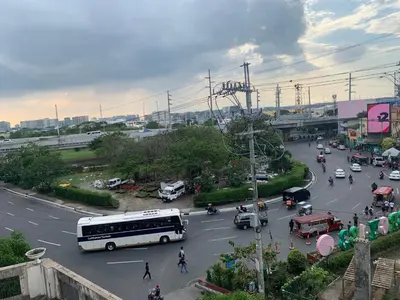a bus is driving down a street with traffic at Pasay staycation @150Newport in Manila