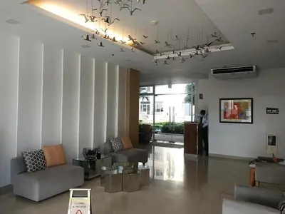 a living room with a couch and a chandelier at SM South Residences, 1 bedroom with balcony. in Manila