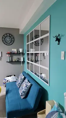 a room with a blue couch and a shelf at Chic Nordic Condo Unit at Shore Residences Mall of Asia in Manila