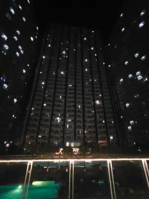 a tall building at night with a pool in front at Gabriel's Den @ JazzB1109 in Manila