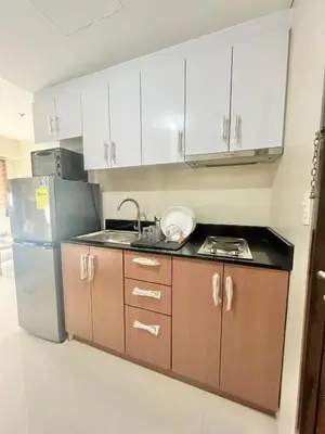 a kitchen with white cabinets and a stainless steel refrigerator at Luxury Hotel Type Condo near NAIA Manila Airport in Manila