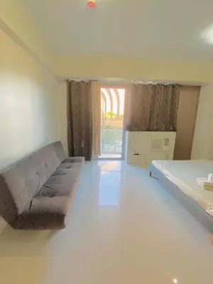 a room with a couch and a bed and a window at Luxury Hotel Type Condo near NAIA Manila Airport in Manila
