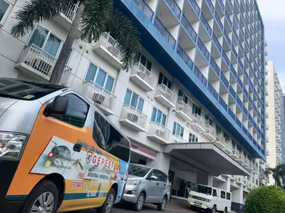 an orange van parked in front of a building at Sea Residences in Manila
