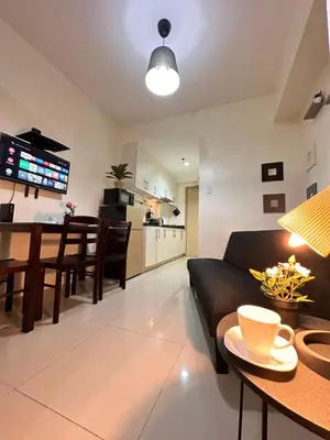 a living room and kitchen with a couch and a table at Sea Residences in Manila