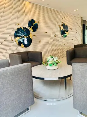 a room with a table and chairs and a wall with clocks at Sea Residences in Manila