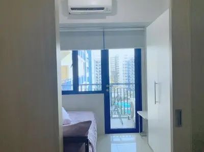a bedroom with a bed and a window with a balcony at Sea Residences - Val Alano in Manila