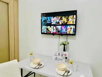 a table with two cups and a tv on the wall at Sea Residences - Val Alano in Manila