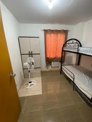 a room with two bunk beds and a fan at Sunmiles Condominium - 2BR unit M26 in Calamba