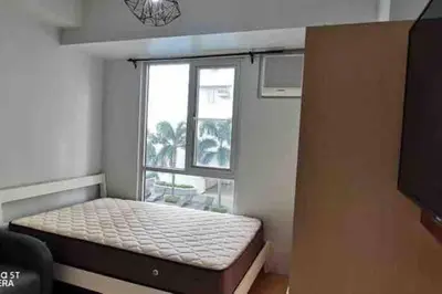 a small room with a bed in front of a window at Minimalist 1 Bedroom in Alabang near Molito and ATC with WiFi & Netflix m in Manila