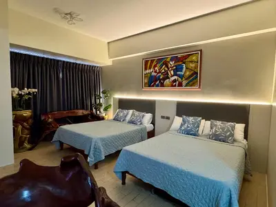 a hotel room with two beds and a chair at Cozyvilla at 81 Newport Blvd NEWLY RENOVATED walk to NAIA T3 Marriott & Resorts World Casino & Newport Mall for 5 Pax FREE PARKING!!!! in Manila