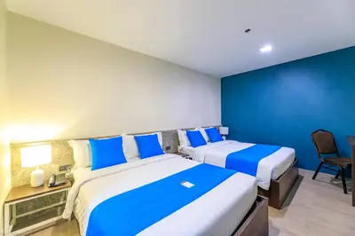 two beds in a room with blue and white at Fynn Boutique Hotel in Bacoor