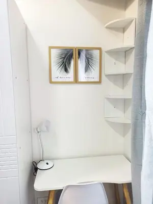 a white room with a desk and two pictures on the wall at Fully Furnished 1 Bedroom at SMDC Air Residence with Balcony City View in Manila