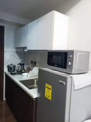 a kitchen with a microwave on top of a refrigerator at Fully Furnished 1 Bedroom at SMDC Air Residence with Balcony City View in Manila