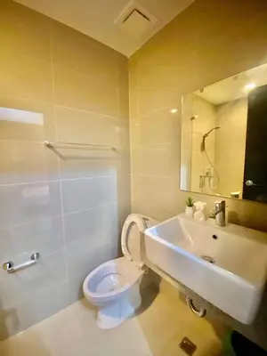 a bathroom with a toilet and a sink and a mirror at Uptown Parksuites in Manila