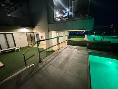 a swimming pool on top of a building at night at 2 Bedroom Service Apartment In Quezon City in Manila