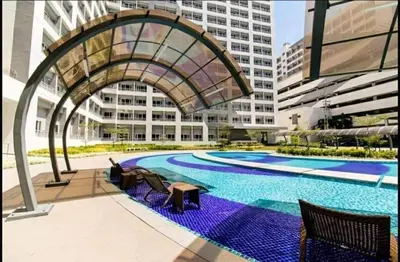 a large swimming pool with chairs and a building at Apad@graceresidences nr BGC in Manila
