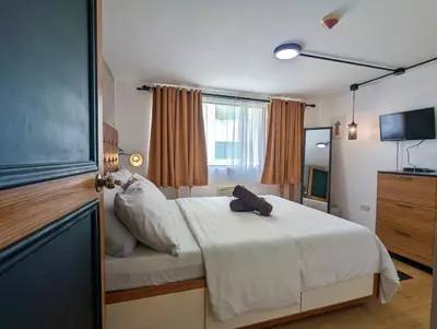 a bedroom with a white bed and a television at Budget 1BR Loft Apartment in Cainta Cambridge Village in Cainta