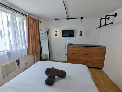 a bedroom with a bed with a towel on it at Budget 1BR Loft Apartment in Cainta Cambridge Village in Cainta